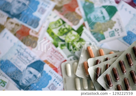 Pakistan rupees banknotes and medicine pills. Pakistan money bills with drugs close up Pakistan rupees banknotes and medicine pills. Pakistan money bills with drugs close up 129222559