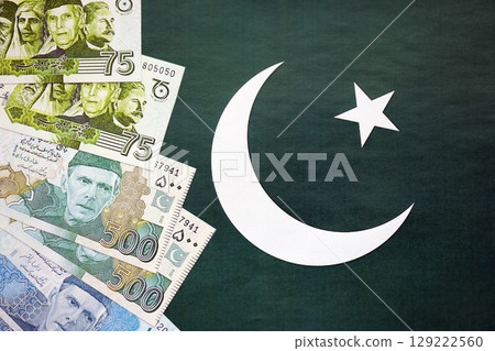 Pakistan rupees banknotes on Pakistani flag background. The current Pakistan money bills 129222560