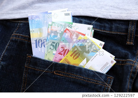 Swiss franc banknotes in denims pocket. The current francs money bills lies in jeans pocket 129222597