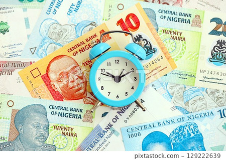 Nigerian naira currency money bills and alarm clock. The concept of time management and income 129222639