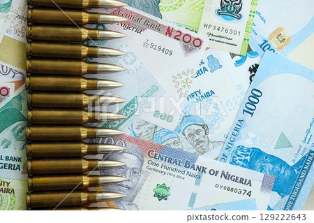 Nigerian naira currency money bills and rifle bullets. The concept of warfare and gun selling 129222643
