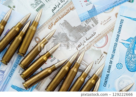 United Arab Emirates dirham currency money bills and rifle bullets. The concept of warfare and gun selling 129222666