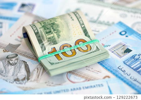 United Arab Emirates dirham currency money bills and bunch of us dollar banknotes. The concept of economics and currency exchange United Arab Emirates dirham currency money bills and bunch of us dollar banknotes. The concept of economics and currency exchange 129222673