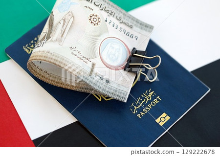 United Arab Emirates dirham currency money bills and passport lies on flag. The concept of travel and vacation 129222678