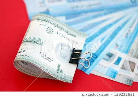 United Arab Emirates dirham money bills in big amount on red. Finance and banking concept 129222681