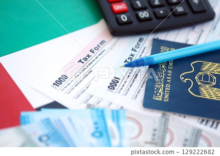 United Arab Emirates dirham money bills and calculator with tax form on flag. Taxation and accounting concept 129222682