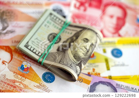 Philippines peso currency money bills and bunch of us dollar banknotes. The concept of economics and currency exchange 129222698