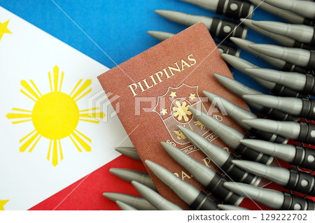 Philippines passport and rifle bullets on flag. The concept of warfare and gun selling 129222702