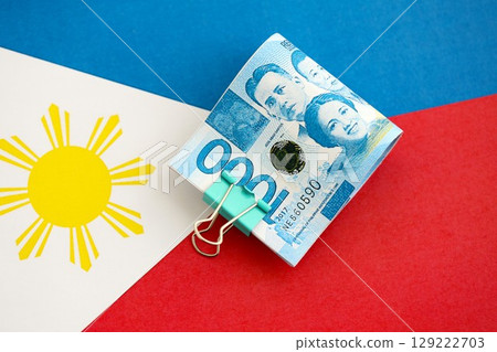 Philippines peso currency money bills lies on flag. The concept of business and investment Philippines peso currency money bills lies on flag. The concept of business and investment 129222703