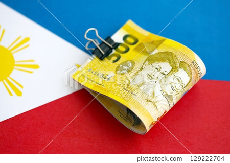 Philippines peso currency money bills lies on flag. The concept of business and investment Philippines peso currency money bills lies on flag. The concept of business and investment 129222704