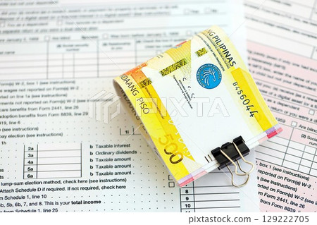Philippines peso money bills on tax form. Taxation and accounting concept 129222705