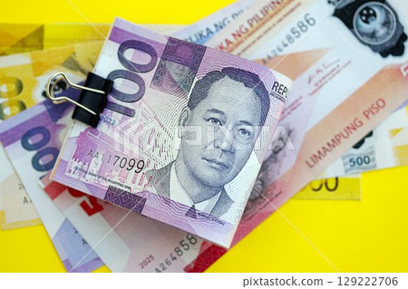 Philippines peso money bills in big amount on yellow. Finance and banking concept Philippines peso money bills in big amount on yellow. Finance and banking concept 129222706