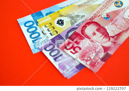 Philippines peso money bills in big amount on red. Finance and banking concept Philippines peso money bills in big amount on red. Finance and banking concept 129222707