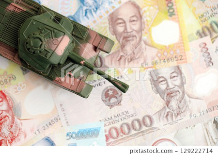 Vietnamese dong currency money bills and toy tank. The concept of army funds and weapons sales 129222714