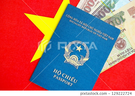 Vietnamese dong currency money bills and passport lies on flag. The concept of travel and vacation 129222724