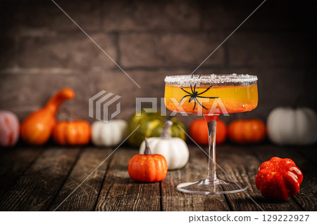 Halloween-Themed Cocktail with Pumpkins and Spider Decoration 129222927