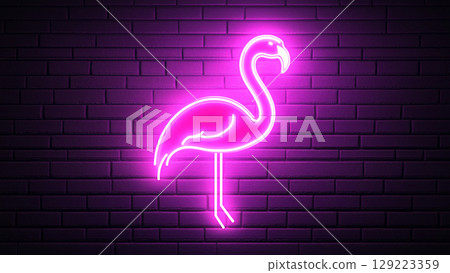 Bright pink neon flamingo illuminating a dark brick wall 129223359