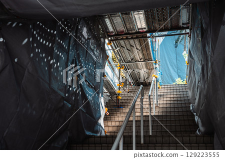Scaffolding and protective sheets installed on the stairs of a building 129223555