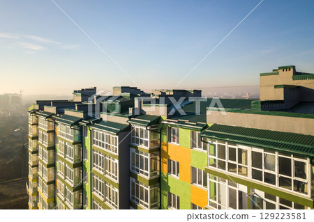Aerial view of a tall residential apartment building with many windows and balconies. 129223581