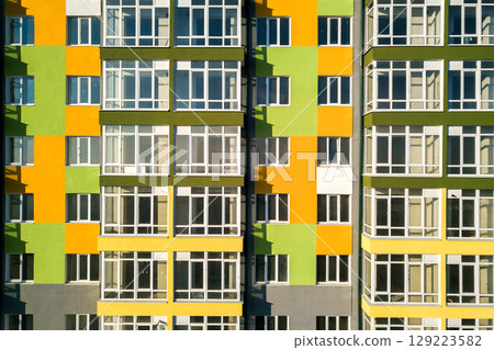 Aerial view of a tall residential apartment building with many windows and balconies. 129223582
