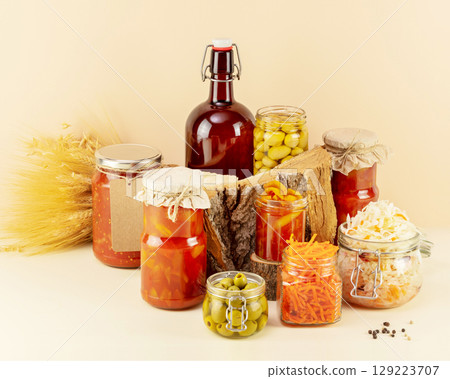 Probiotic food. Pickled or fermented products. Fermented vegetables and mushrooms in glass jars, bottle with home made beer. Home food preserving or canning. Preserving the harvest 129223707