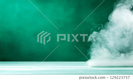 Mysterious white smoke creeping over a light wooden surface with a textured green background, creating a dramatic and intriguing atmosphere 129223737