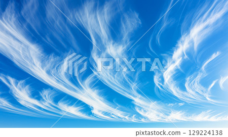 Elegant cirrus clouds create a mesmerizing display against a deep blue sky, resembling delicate brushstrokes of white 129224138