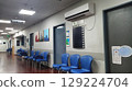 Modern Israeli Hospital Interior Waiting Area with Blue Chairs and Directional Signage 129224704