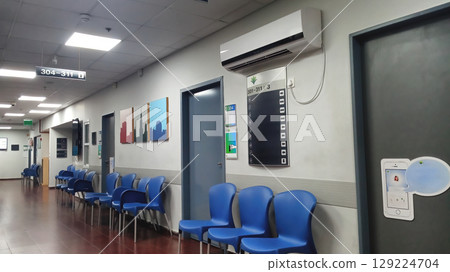Modern Israeli Hospital Interior Waiting Area with Blue Chairs and Directional Signage 129224704
