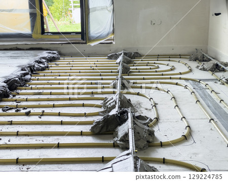 Installation of heating pipes under cement floor. 129224785