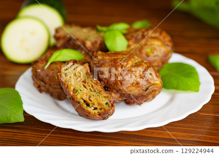 Healthy vegetable muffins with herbs and zucchini on a dark wooden table Healthy vegetable muffins with herbs and zucchini on a dark wooden table 129224944