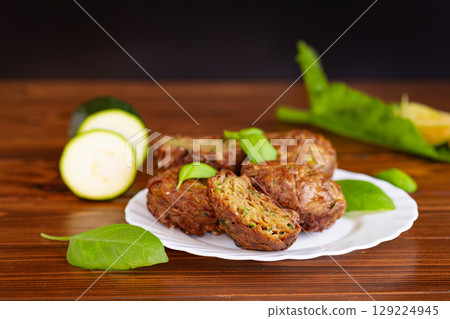 Portioned vegetable muffins with herbs on a dark wooden table Portioned vegetable muffins with herbs on a dark wooden table 129224945