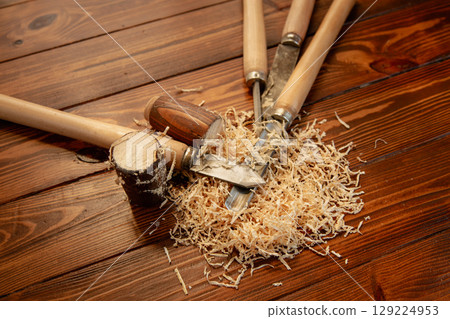 Chisels and wood shavings on wooden table Chisels and wood shavings on wooden table 129224953