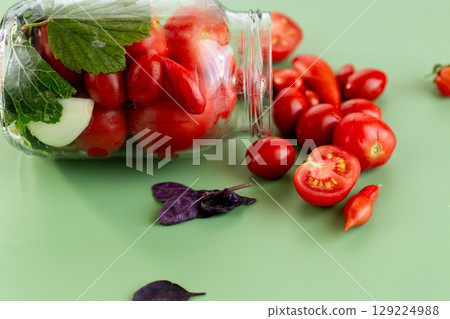 Close-up of rolling tomatoes with fresh herbs and drops of dew 129224988