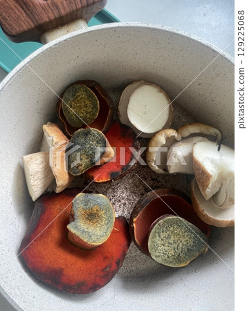 Sliced wild mushrooms in ceramic pot ready for cooking. healthy food, vegetarian meal concept in rustic kitchen. 129225068