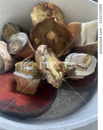 Sliced wild mushrooms in ceramic pot ready for cooking. healthy food, vegetarian meal concept in rustic kitchen. 129225069