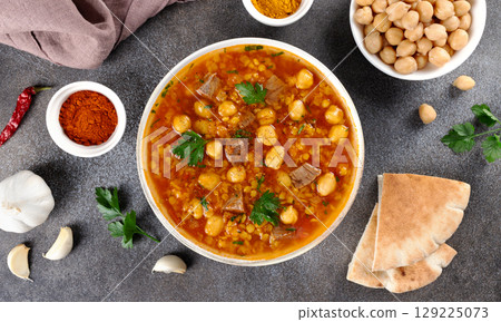 Moroccan harira soup with ingredients, spices and arabic bread on grey background. Top view. Ramadan iftar food. 129225073