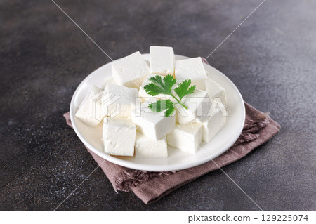 Cubes of Indian paneer cheese on dark background. Indian food. 129225074