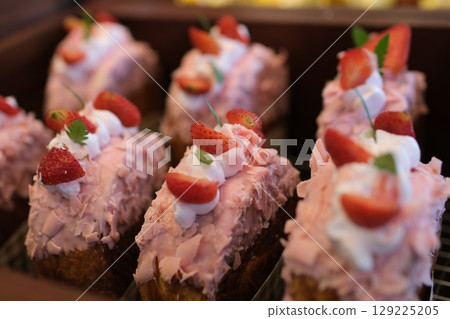 White chocolate strawberry yogurt cake decorated with fresh fruits and chocolate chunk on wood table. Delicious and sweet pink strawberry cake for Valentines or birthday party. Homemade bakery concept 129225205