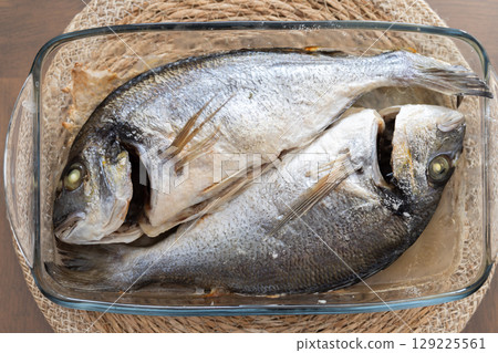 Two Freshly Prepared Fish in a Glass Baking Dish for Cooking 129225561
