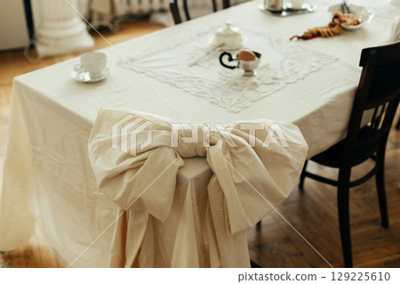 Decor tied tablecloth in the shape of a bow tie on a table in the kitchen living room. 129225610