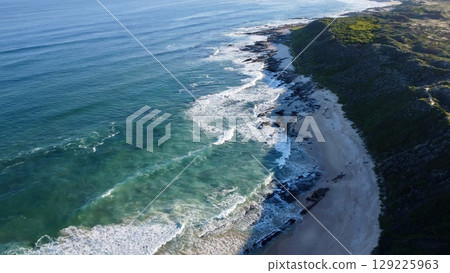 Morning Footsteps Along Serene Sandy Shoreline 129225963