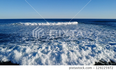 Morning Footsteps Along Serene Sandy Shoreline 129225972