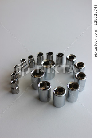 Chrome Shiny Set Of Sockets For Quick Release Ratchet In A Spiral Row On A White Surface 129226743