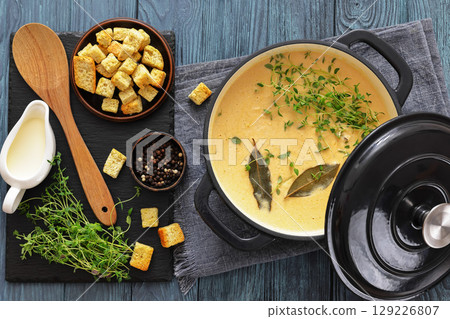 creamy salmon soup with herb in a pot 129226807