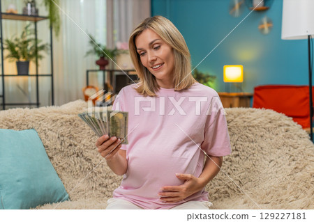 Pregnant woman counting dollars cash money planning budget for childbirth calm financial security 129227181