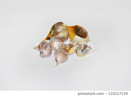 unpeeled heads of garlic on a white background 129227230