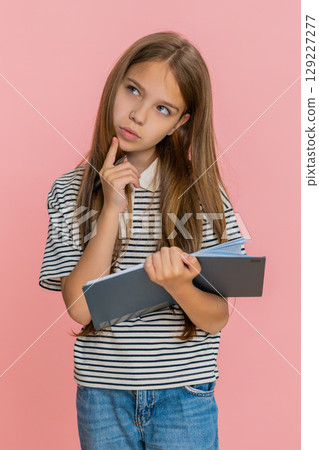 Child girl kid thoughtfully writing notes in notebook diary carefully planning detailed to-do list Child girl kid thoughtfully writing notes in notebook diary carefully planning detailed to-do list 129227277