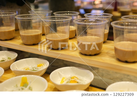 Taiwan brown sugar fresh milk bubble tea glass on white background. Cheese Cream fresh milkfoam with Black pearl tapioca bubble tea with brown sugar syrup glass, tea leaves and floating bubbles tea  129227309