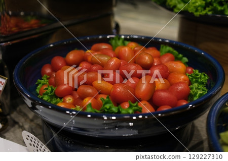 Fresh cherry tomatoes aiko in Wooden bowll on white background 129227310